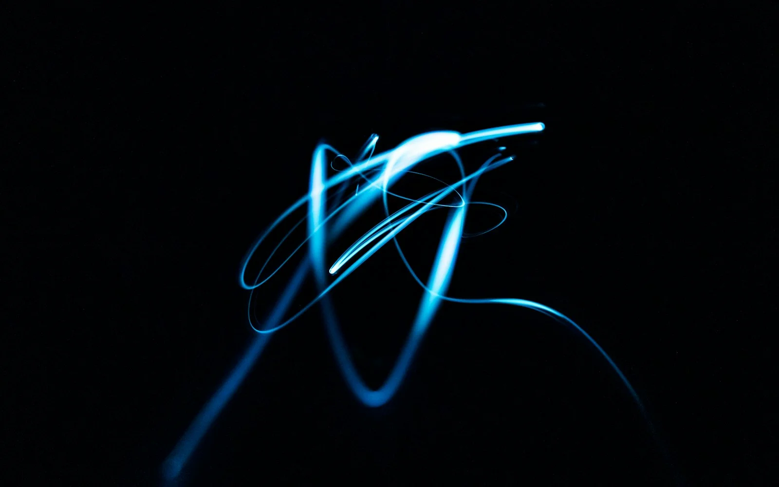 A single blue light trail looped into a knot against black.