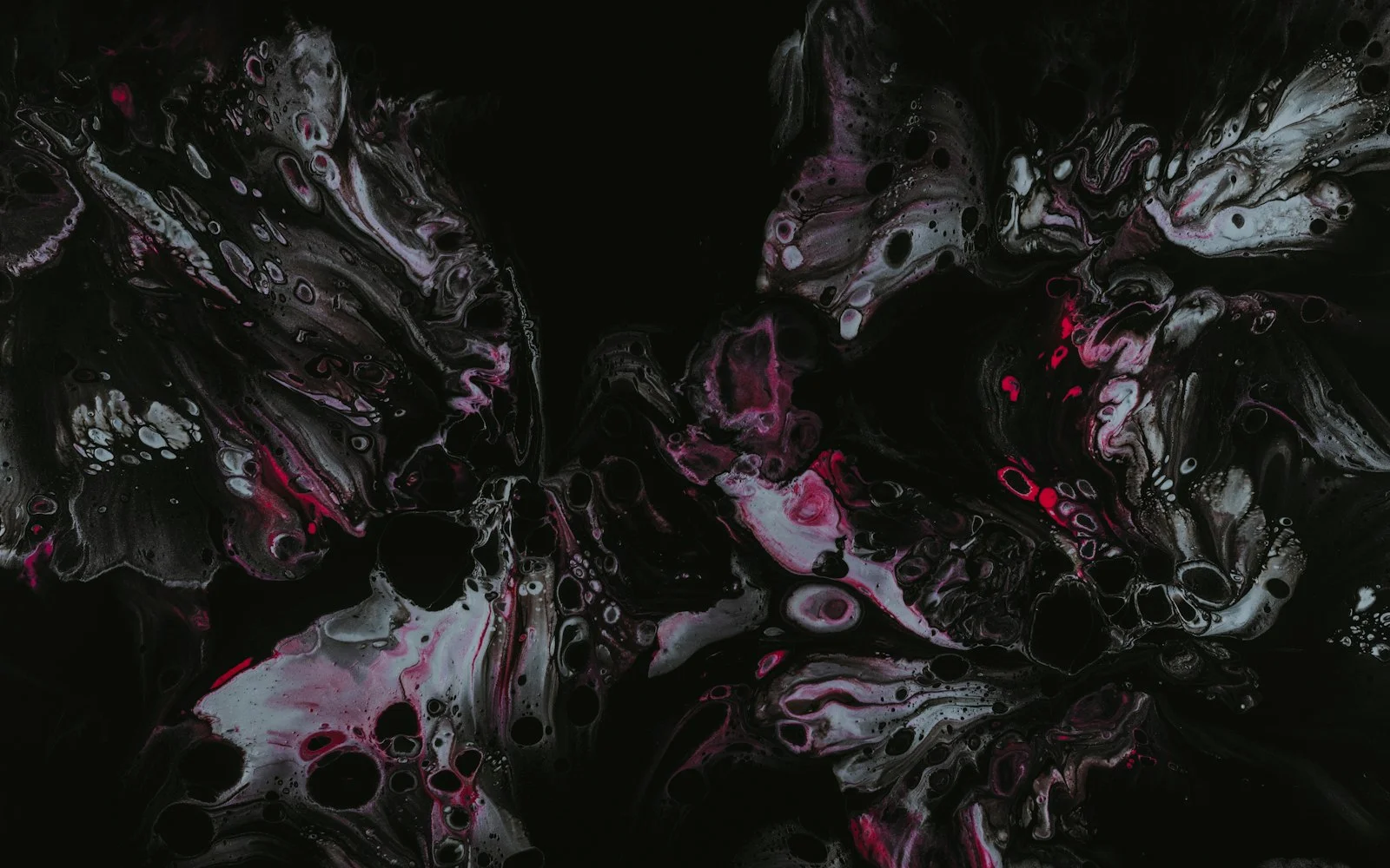 Marbled paint in white and hot pink breaking into bubbled cells on black.