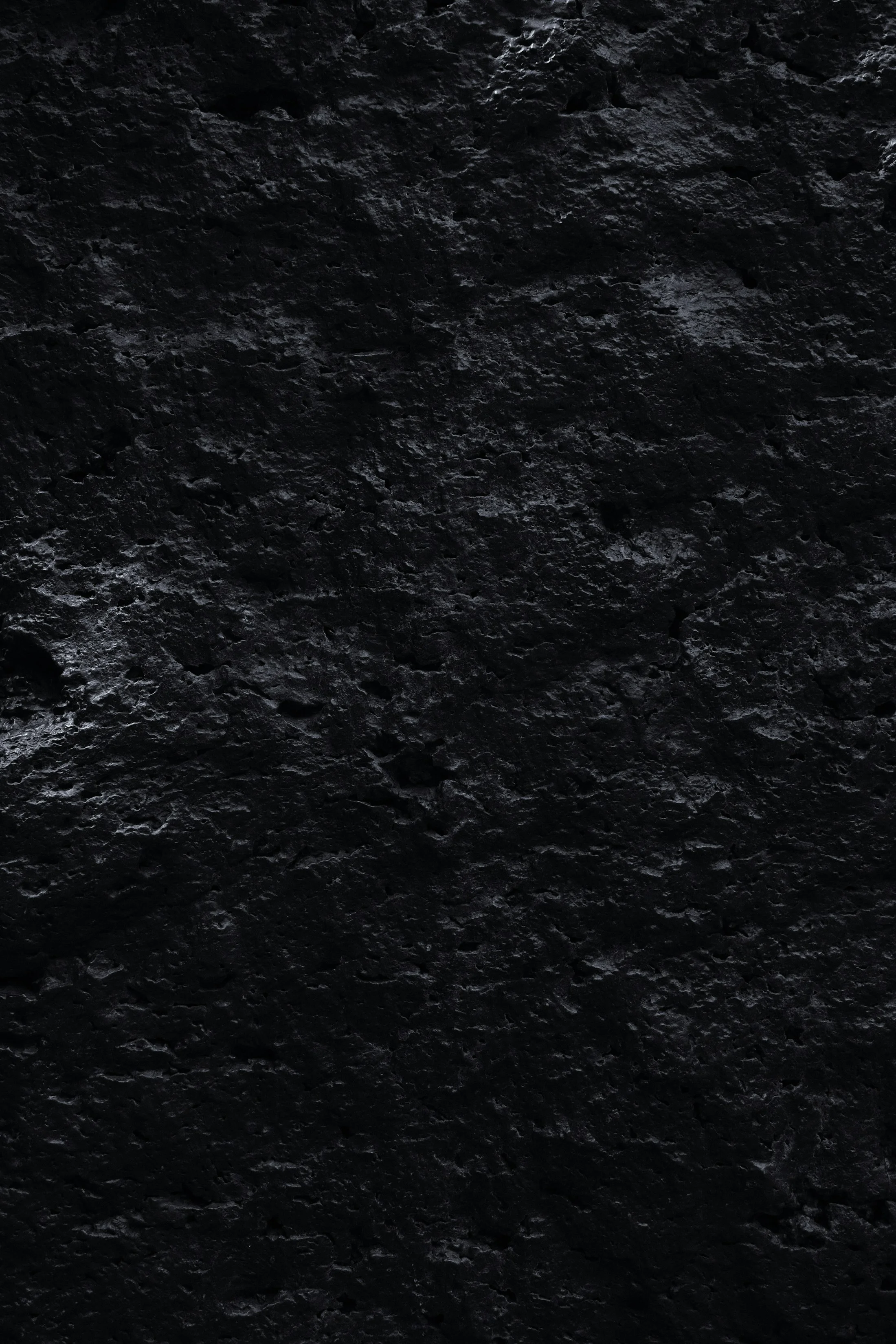 Close-up of a rough, pitted black stone surface.